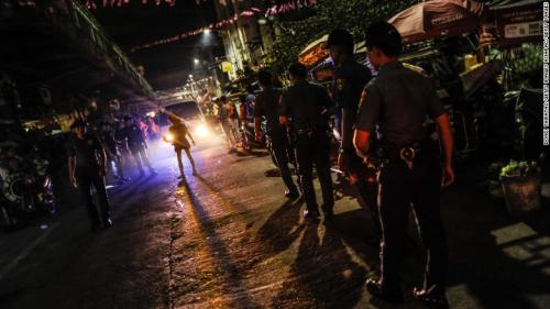 Police patrol a neighborhood in Manila